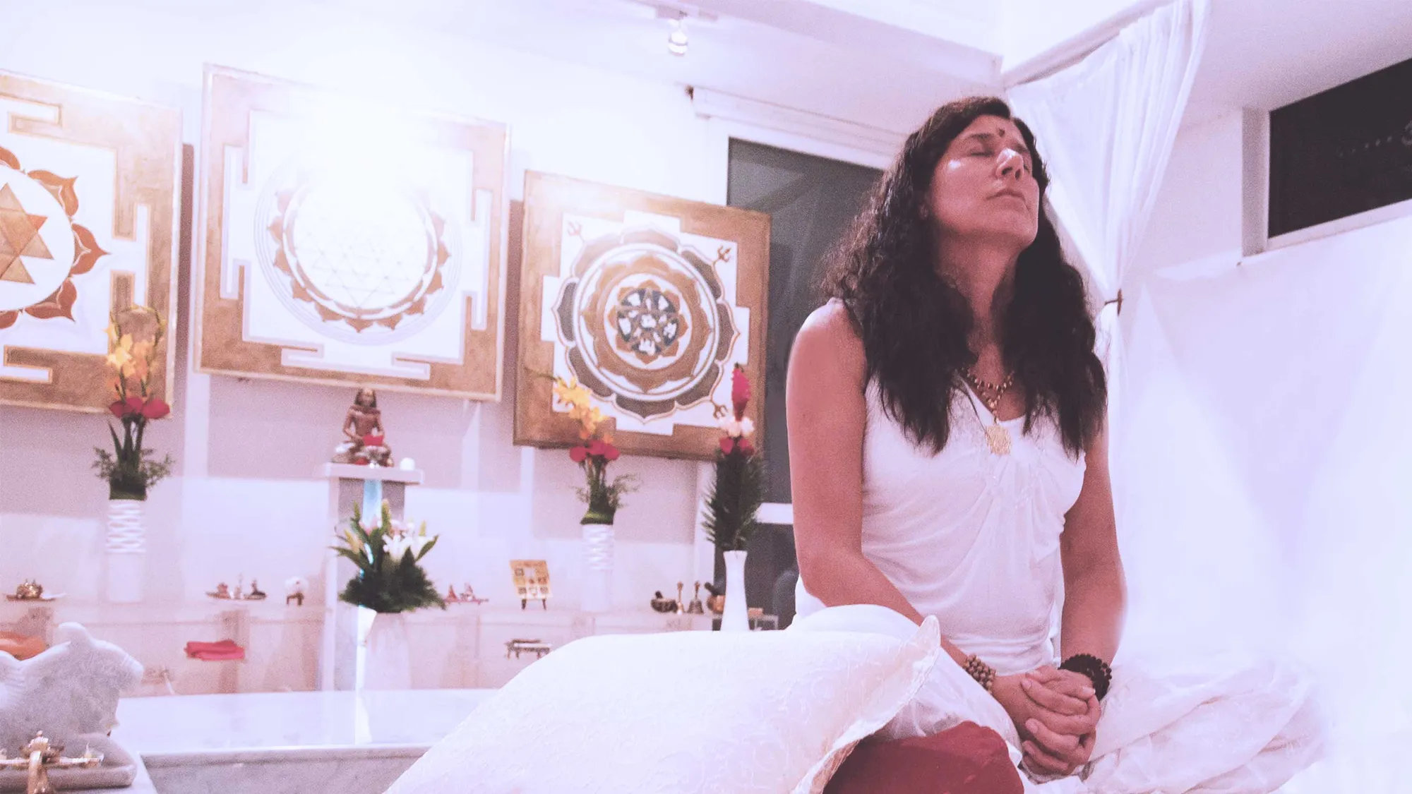 Mataji Shaktiananda seated in a white room with yantras