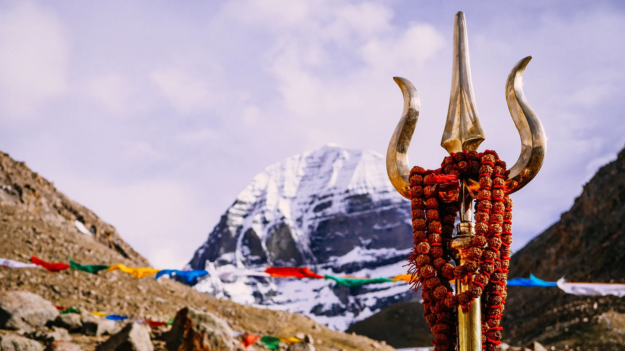 Trident with a garland before snow-capped Mount Kailash